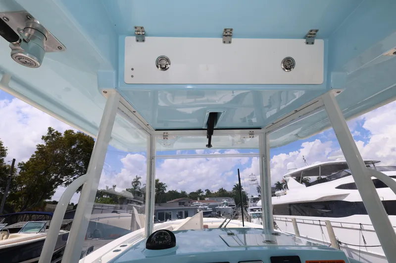 Slide: The Image of 2019 Cobia 320 Center Console boat interior with clear sky and marina view. - 14