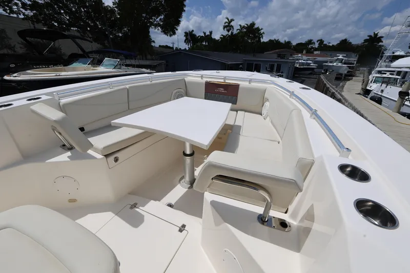 Slide: The Image of 2019 Cobia 320 Center Console boat with spacious seating and table setup. - 16