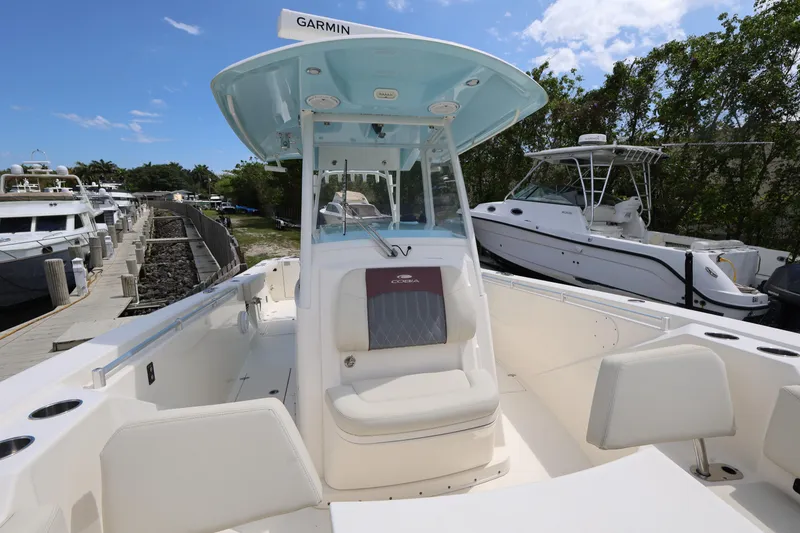 Slide: The Image of 2019 Cobia 320 Center Console boat docked, featuring spacious seating and Garmin equipment. - 18
