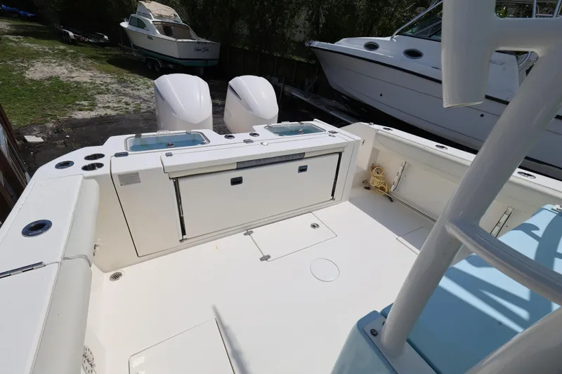 Slide: The Image of 2019 Cobia 320 Center Console boat deck with twin engines and storage compartments. - 24