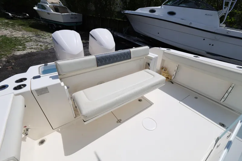 Slide: The Image of 2019 Cobia 320 Center Console boat with white seating and dual engines. - 26