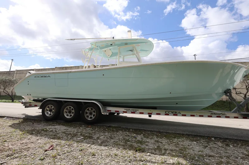 Slide: The Image of 2019 Cobia 320 Center Console boat on trailer under cloudy sky. - 8