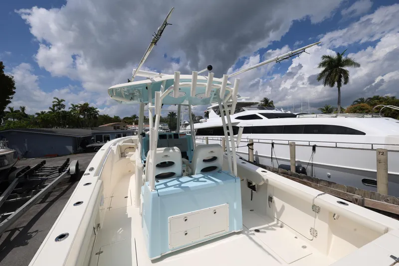 Slide: The Image of 2019 Cobia 320 Center Console boat docked under cloudy sky. - 9