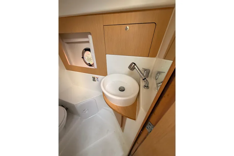 Slide: The Image of 2013 Beneteau Flyer GT 34 bathroom with toilet, shower, and porthole window. - 14