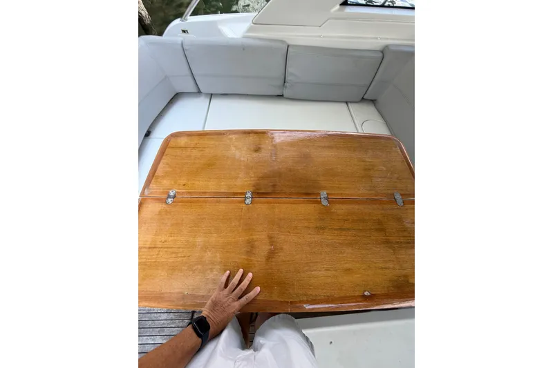 Slide: The Image of 2013 Beneteau Flyer GT 34 cockpit with wooden table and cushioned seating. - 6