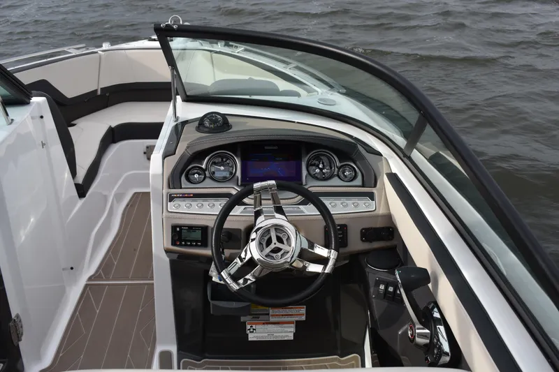 Slide: The Image of 2024 Monterey 255SS Super Sport boat dashboard with steering wheel and controls on water. - 18