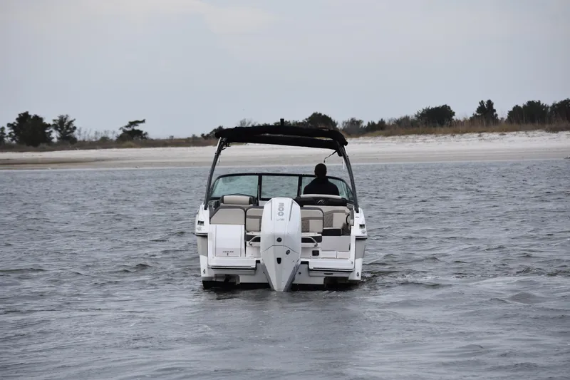 Slide: The Image of 2024 Monterey 255SS Super Sport boat cruising near a sandy shoreline. - 2