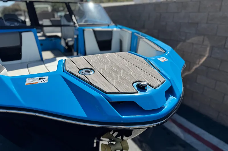 Slide: The Image of 2023 Yamaha Boats 222XD, blue exterior, close-up of bow with seating area. - 11
