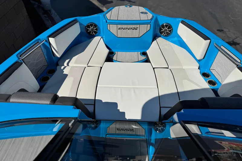 Slide: The Image of 2023 Yamaha Boats 222XD interior with blue and white seating, cup holders, and speakers. - 14