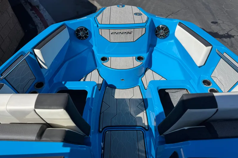 Slide: The Image of 2023 Yamaha Boats 222XD interior, featuring blue and gray seating with cup holders and speakers. - 15