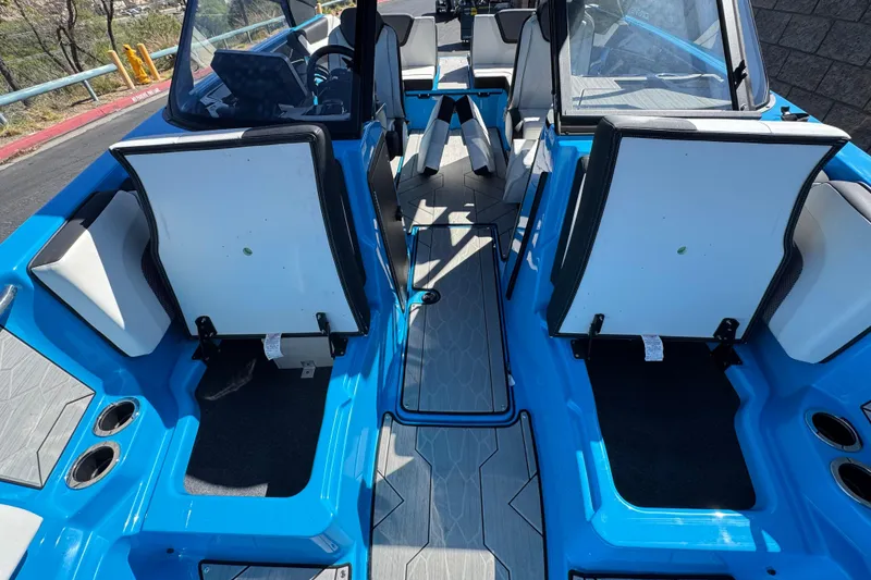 Slide: The Image of 2023 Yamaha Boats 222XD interior with blue and white seating, open storage compartments. - 16