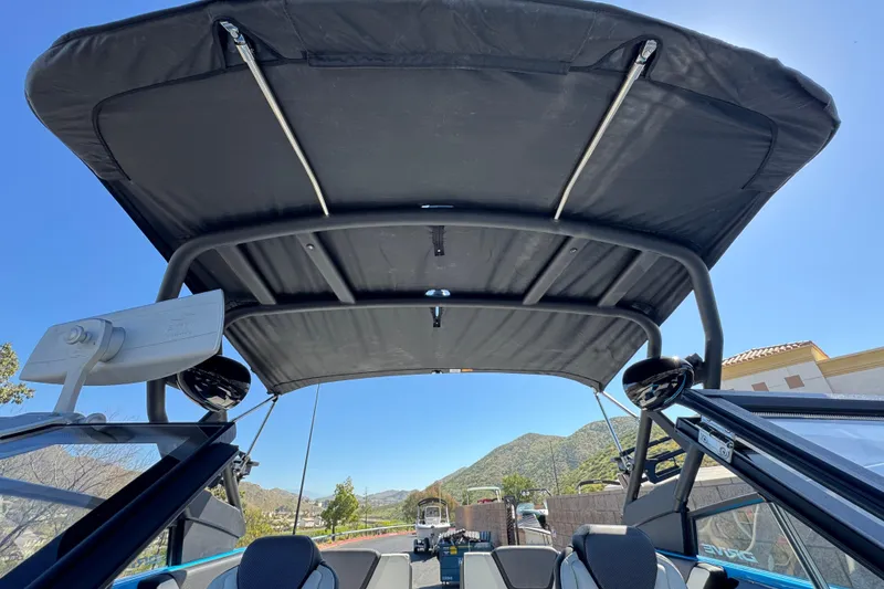 Slide: The Image of 2023 Yamaha Boats 222XD interior view with canopy, showcasing sleek design and mountain backdrop. - 17
