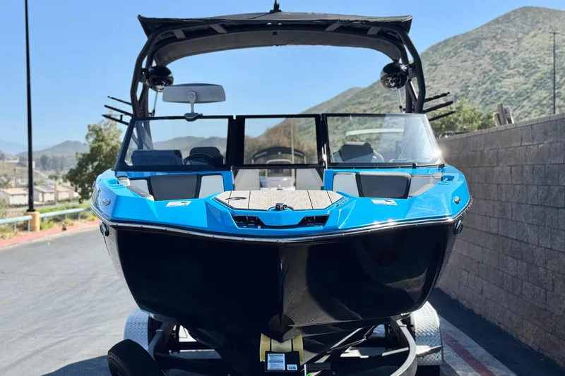 Slide: The Image of 2023 Yamaha Boats 222XD in blue, parked with scenic mountain backdrop. - 2
