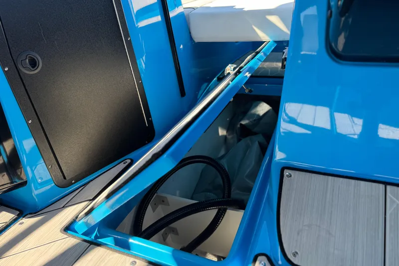 Slide: The Image of 2023 Yamaha Boats 222XD storage compartment with blue exterior and open hatch. - 20
