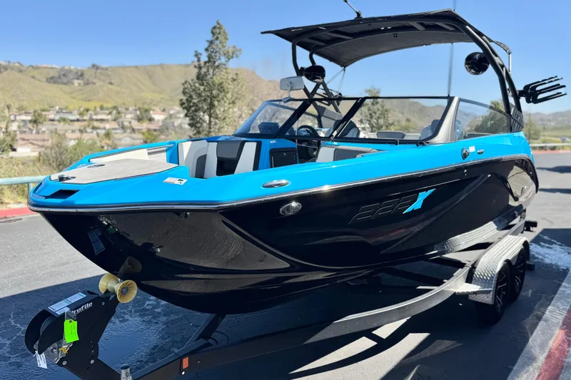 Slide: The Image of 2023 Yamaha Boats 222XD in blue and black, parked on a trailer, scenic background. - 3