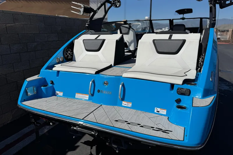 Slide: The Image of 2023 Yamaha Boats 222XD, blue exterior, rear view with seating and swim platform. - 6