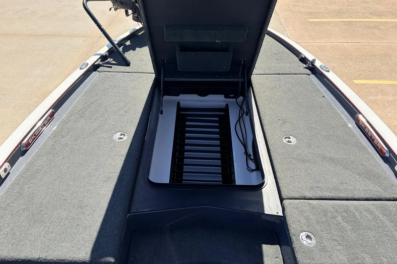Slide: The Image of 2019 Skeeter FX21 Apex boat with open storage compartment, gray carpeted deck. - 14
