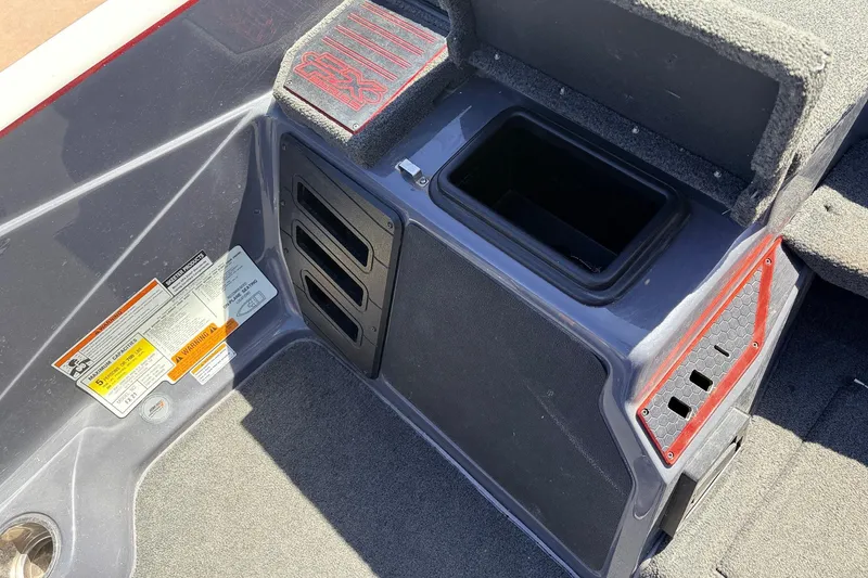 Slide: The Image of 2019 Skeeter FX21 Apex boat interior with storage compartment and warning labels. - 22