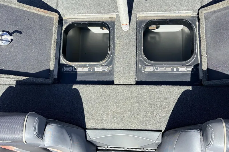 Slide: The Image of 2019 Skeeter FX21 Apex boat storage compartments with open lids, showcasing interior space. - 27