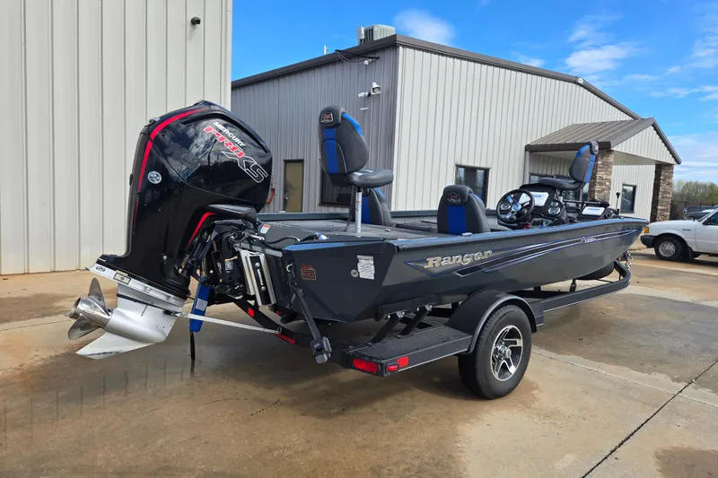 Slide: The Image of 2023 Ranger RT188P boat with powerful outboard motor, parked outside a building. - 4