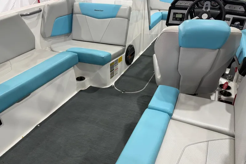 Slide: The Image of 2020 MasterCraft NXT22 boat interior with blue and gray seating, modern dashboard. - 10
