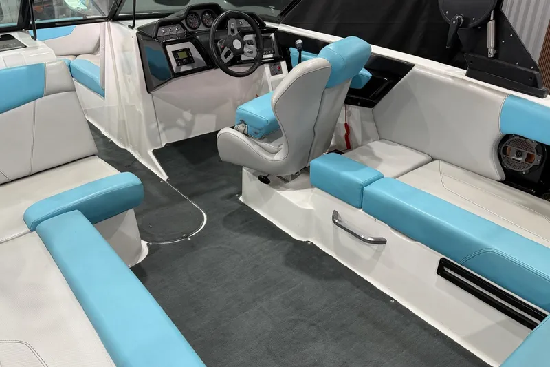 Slide: The Image of 2020 MasterCraft NXT22 boat interior with blue and white seating, modern dashboard, and steering wheel. - 11
