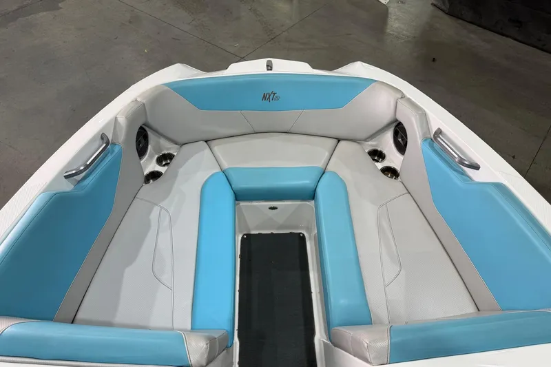 Slide: The Image of 2020 MasterCraft NXT22 boat interior with blue and gray seating, cup holders, and sleek design. - 5