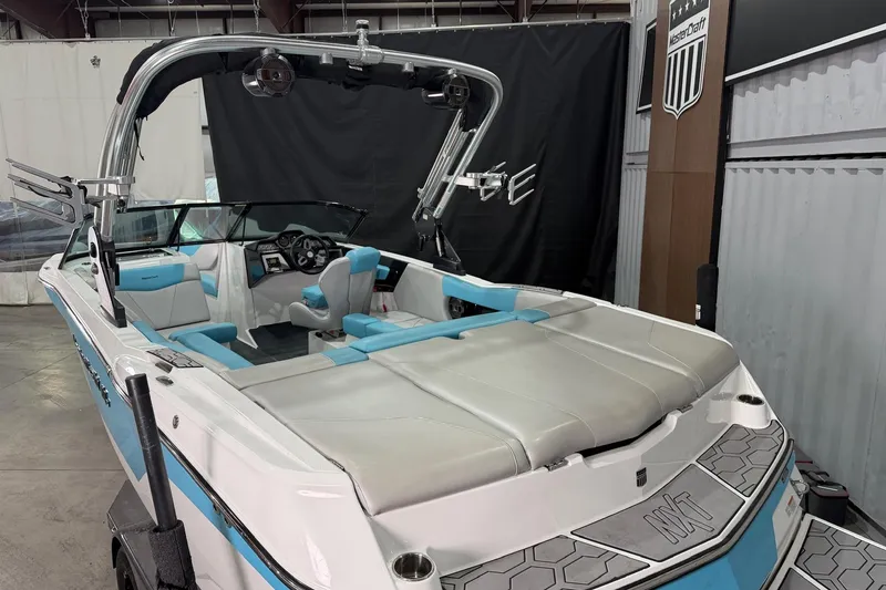 Slide: The Image of 2020 MasterCraft NXT22 boat with blue and white interior, displayed indoors. - 8