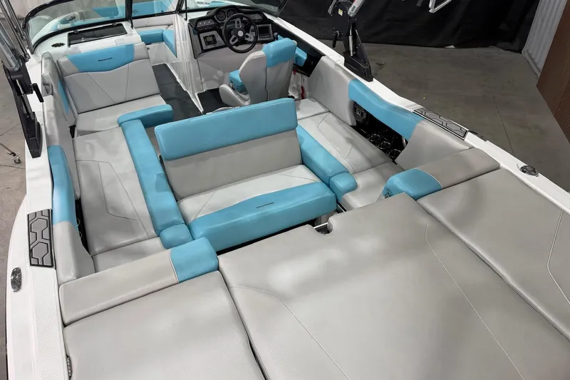 Slide: The Image of 2020 MasterCraft NXT22 boat interior with blue and gray seating, modern dashboard. - 9