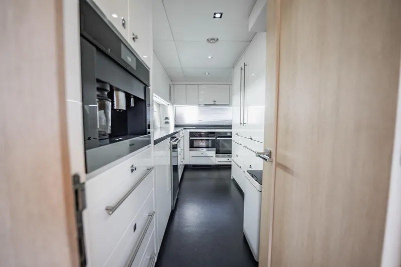 Slide: The Image of Modern kitchen interior on a 2011 Sunseeker 34 Metre Yacht, featuring sleek white cabinetry. - 36