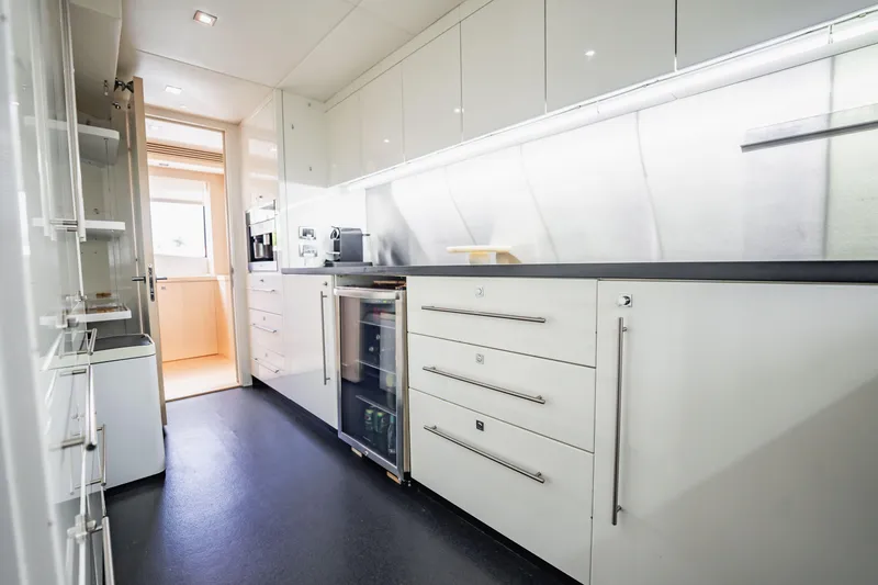 Slide: The Image of Modern kitchen interior on a 2011 Sunseeker 34 Metre Yacht, featuring sleek white cabinetry. - 39