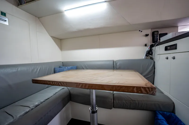 Slide: The Image of Cozy seating area in 2011 Sunseeker 34 Metre Yacht with wooden table and gray cushions. - 77