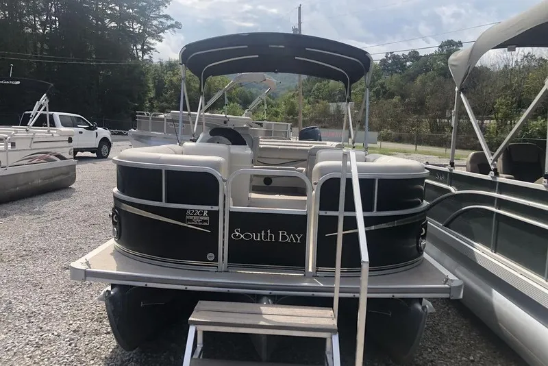Slide: The Image of 2008 South Bay 822 CR Tritoon boat with canopy, parked on gravel lot. - 5