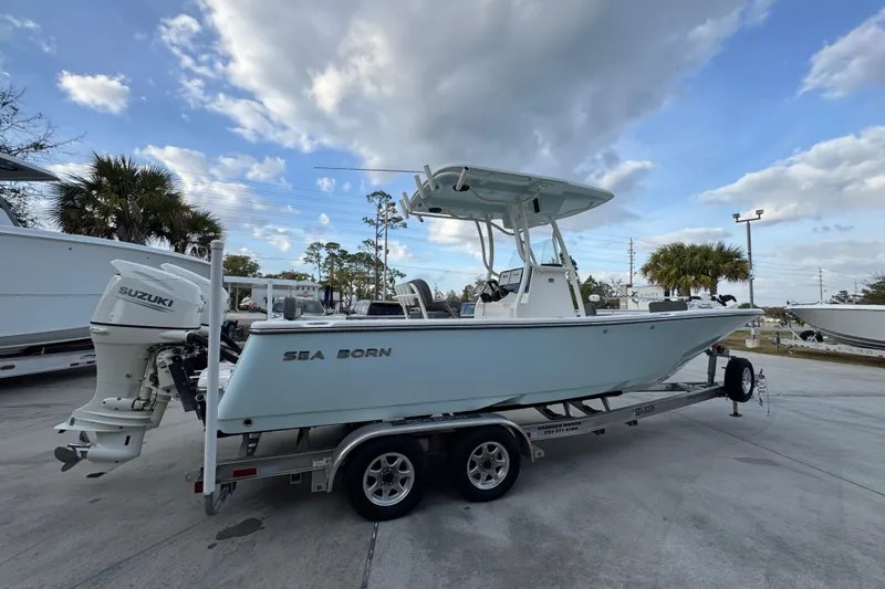 Slide: The Image of 2021 Sea Born LX24 Center Console boat on trailer under cloudy sky. - 10