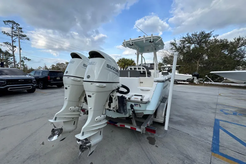 Slide: The Image of 2021 Sea Born LX24 Center Console boat with dual Suzuki outboard motors in a parking lot. - 12