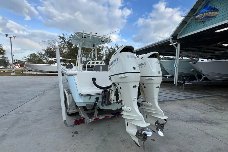 Slide: The Image of 2021 Sea Born LX24 Center Console boat with dual Suzuki outboard motors on a trailer. - 14