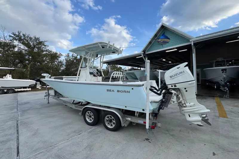 Slide: The Image of 2021 Sea Born LX24 Center Console boat on trailer, parked outside a marina. - 16