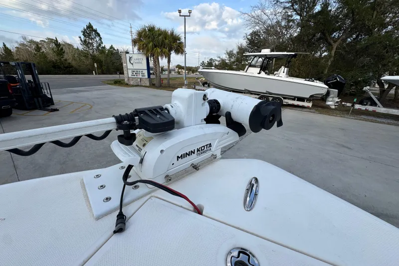 Slide: The Image of 2021 Sea Born LX24 Center Console with Minn Kota trolling motor in a marina setting. - 23