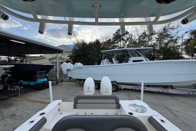 Slide: The Image of 2021 Sea Born LX24 Center Console boat in a marina, surrounded by other vessels. - 28