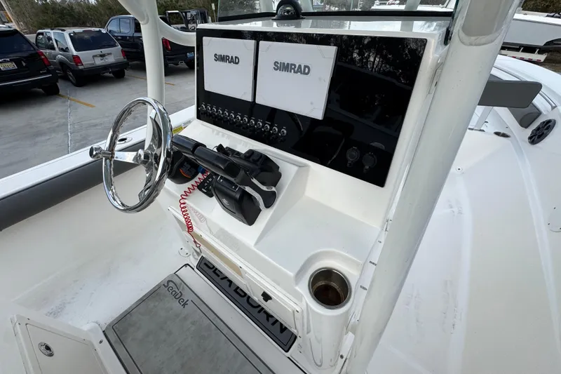 Slide: The Image of 2021 Sea Born LX24 Center Console boat dashboard with Simrad displays and steering wheel. - 31