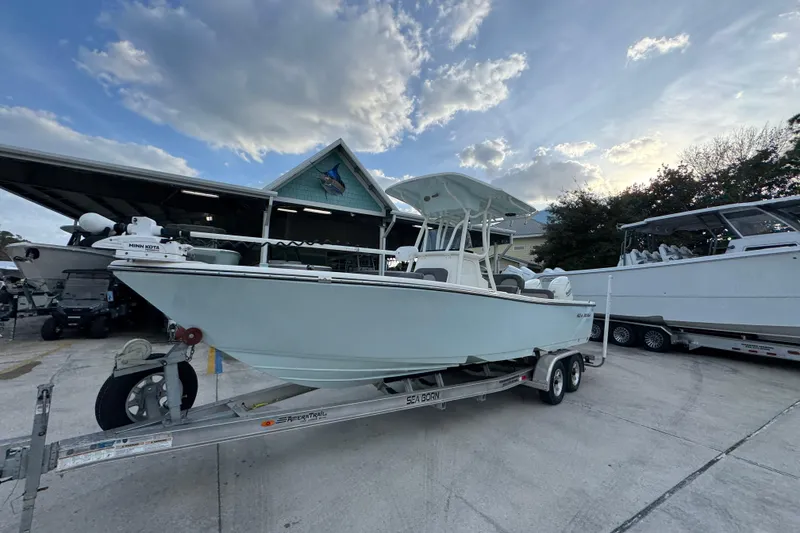 Slide: The Image of 2021 Sea Born LX24 Center Console boat on trailer under cloudy sky. - 4