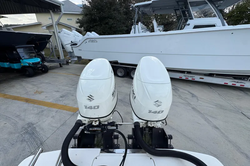Slide: The Image of 2021 Sea Born LX24 Center Console with dual Suzuki 140 outboard engines in a marina setting. - 40