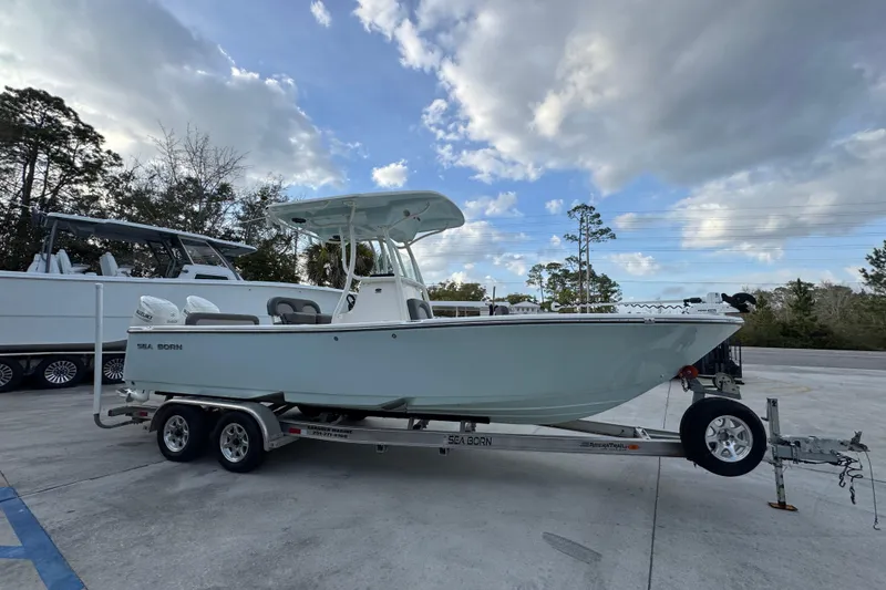 Slide: The Image of 2021 Sea Born LX24 Center Console boat on trailer under cloudy sky. - 8