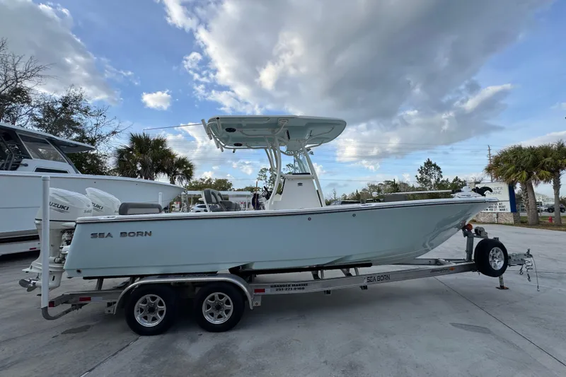 Slide: The Image of 2021 Sea Born LX24 Center Console boat on trailer under cloudy sky. - 9