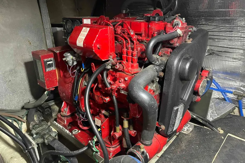 Slide: The Image of 1987 Chris-Craft 426 Catalina bedroom with tropical bedding, TV, and hats on hooks. - 14