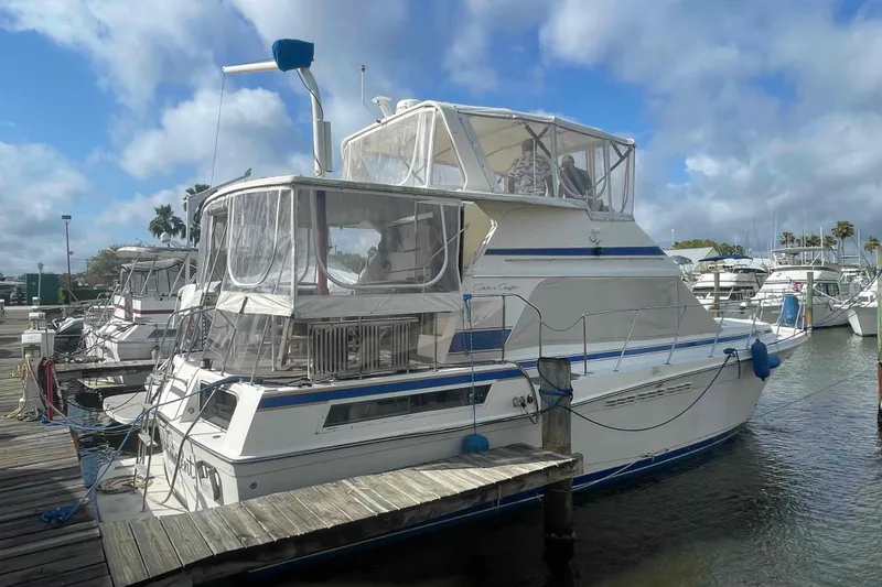 Slide: The Image of 1987 Chris-Craft 426 Catalina boat deck with anchor winch and railing, reflecting sunlight. - 38