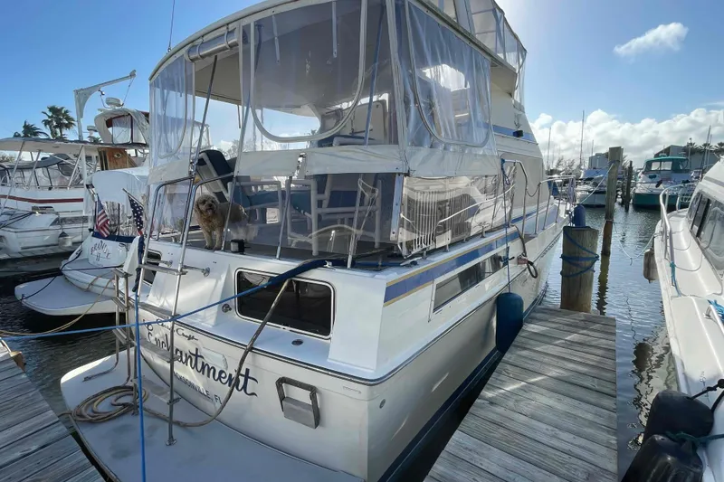 Slide: The Image of 1987 Chris-Craft 426 Catalina docked at marina, featuring enclosed deck and nautical decor. - 41
