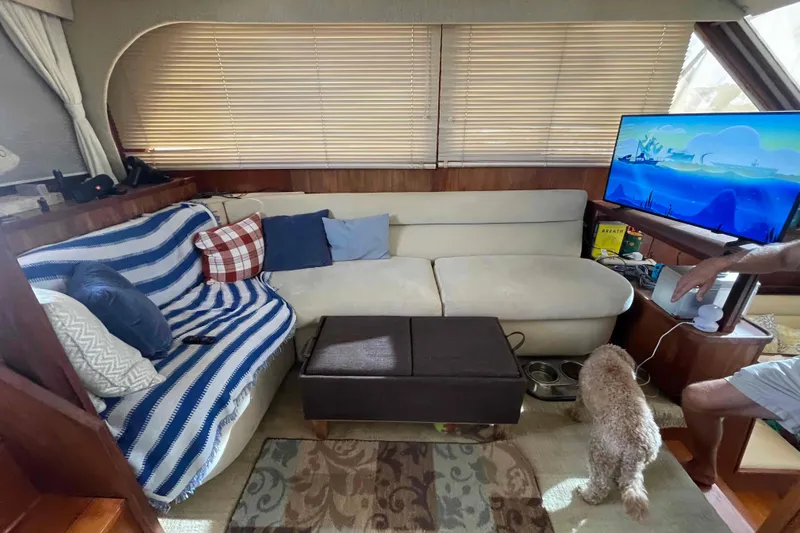 Slide: The Image of 1987 Chris-Craft 426 Catalina interior with dining area, kitchen, and cozy seating. - 8