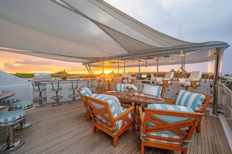 Slide: The Image of Luxurious 2000 Christensen Raised Pilothouse yacht deck with elegant seating and sunset view. - 25