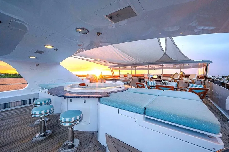 Slide: The Image of Luxurious 2000 Christensen Raised Pilothouse yacht deck with sunset view and elegant seating. - 29